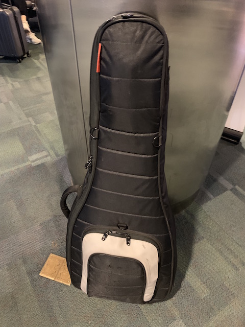 A guitar case built for optimal protection by Mono Creators shown in an airport.