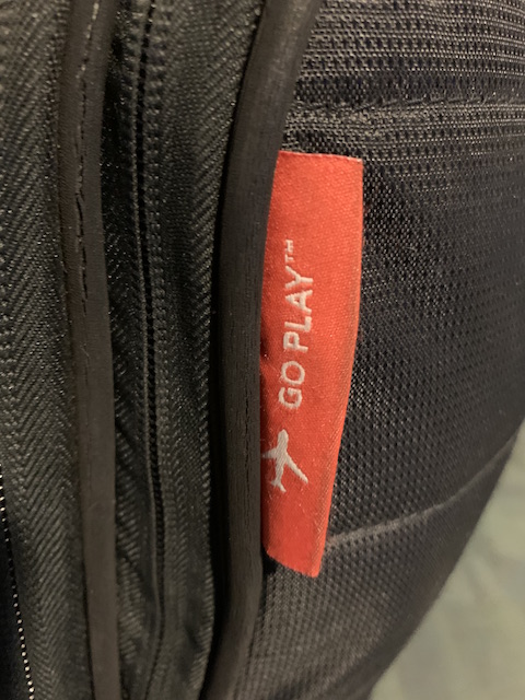 an embroidered tag on a Mono acoustic guitar case shows a jet and the words "Go Play"